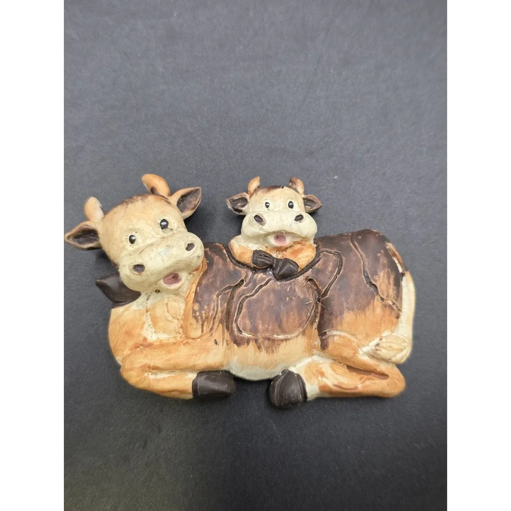 This collection features various vintage-style cow refrigerator magnets